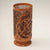 A delicate and intricately-carved cylinder with a Celtic pattern carved on the side. 