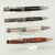 A collection of four unique pens in different materials and mechanisms. 