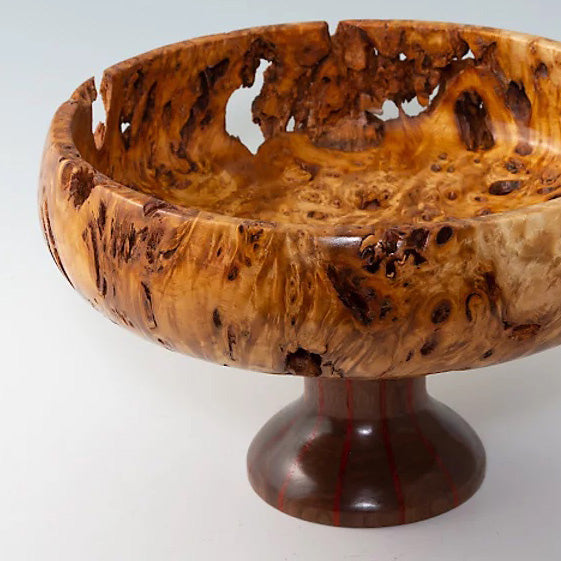 A highly-figured bowl that sits atop a segmented pedestal. 