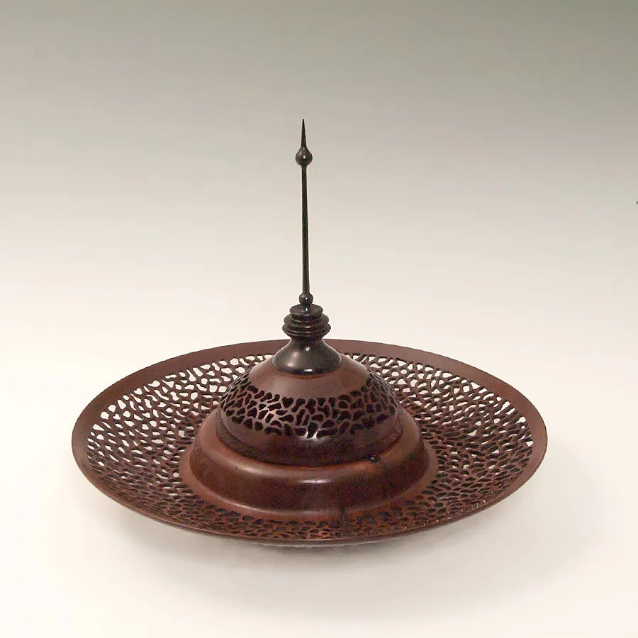 An intricately-carved wooden bowl with a domed lid that has a delicate finial on the top.