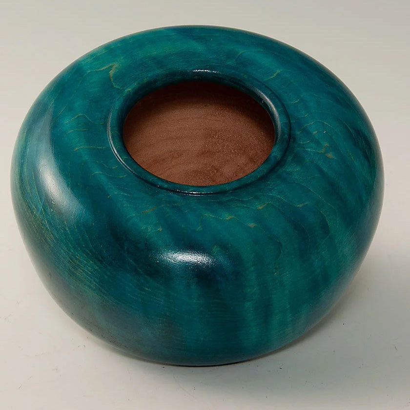 A woodturned vessel dyed in a marbled greenish-blue color
